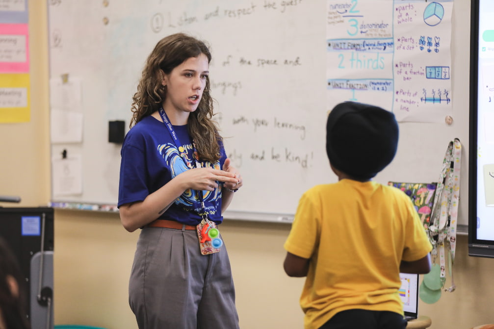 Tutor talking with a student in front of a white board.